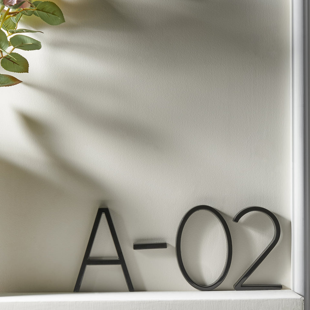 Numéro de maison noir avec chiffres en relief